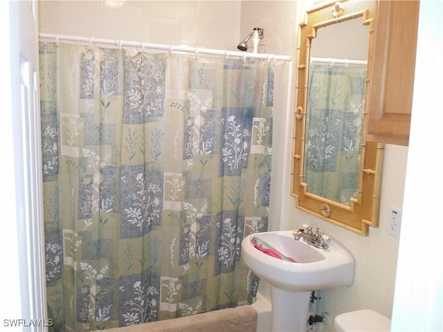 bathroom with curtained shower and toilet