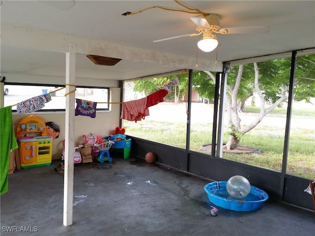 unfurnished sunroom with ceiling fan