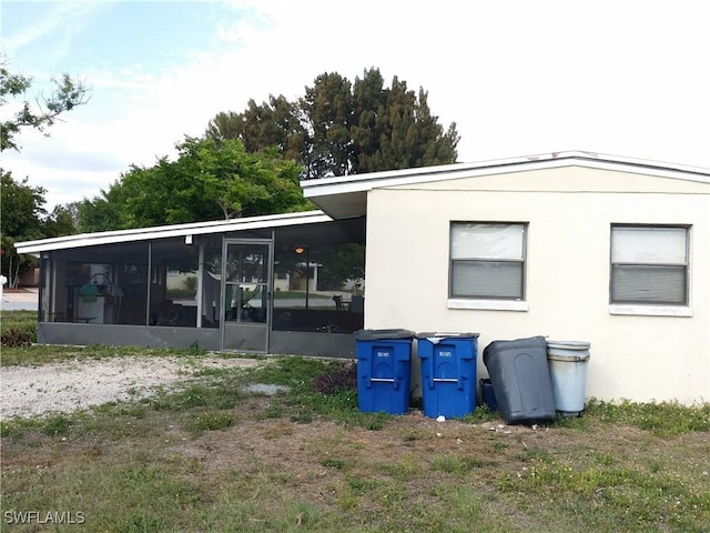 rear view of property featuring a sunroom