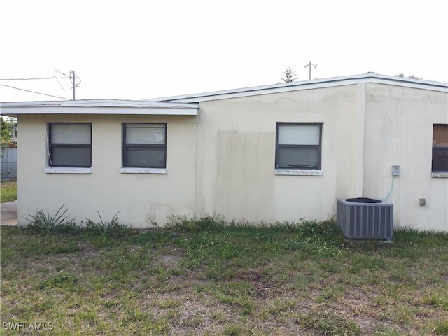 view of side of property featuring a yard and central air condition unit