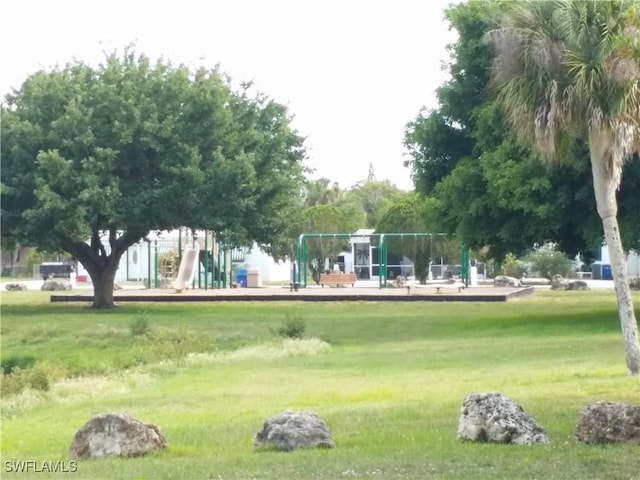 view of home's community featuring a lawn and a playground