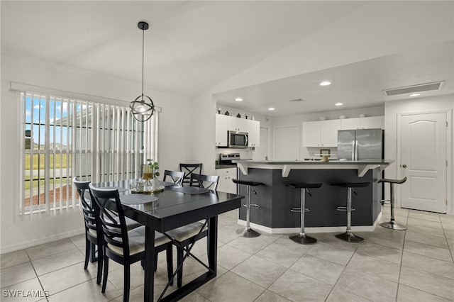 tiled dining area with vaulted ceiling