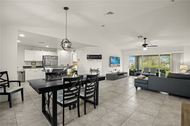 tiled dining room with ceiling fan and vaulted ceiling