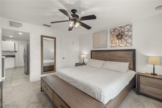 bedroom with light carpet, stainless steel refrigerator, and ceiling fan