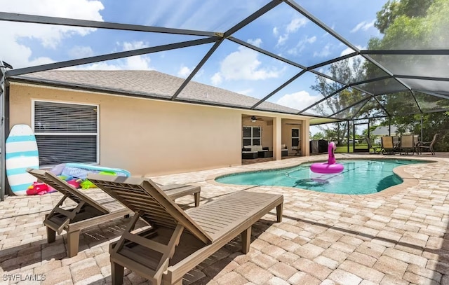 view of pool featuring a patio, ceiling fan, and a lanai