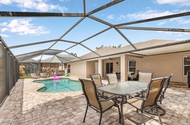 view of swimming pool featuring ceiling fan, a lanai, and a patio