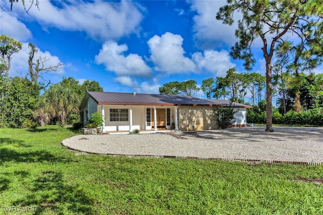 rear view of property featuring a lawn