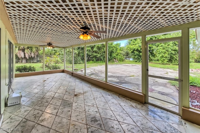 unfurnished sunroom featuring ceiling fan