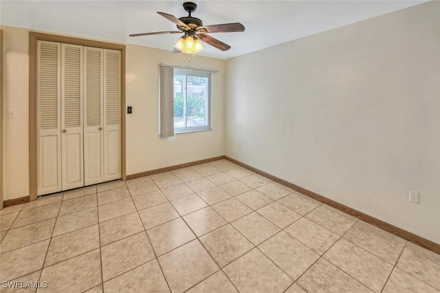 unfurnished bedroom featuring light tile patterned flooring, ceiling fan, and a closet