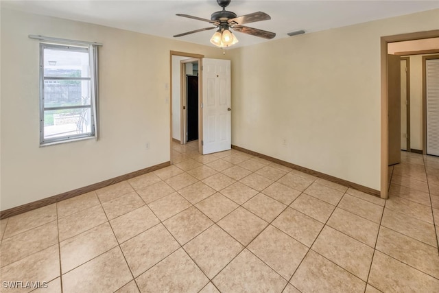 tiled spare room featuring ceiling fan