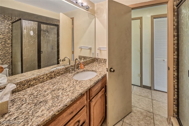 bathroom featuring tile patterned flooring, vanity, and a shower with door