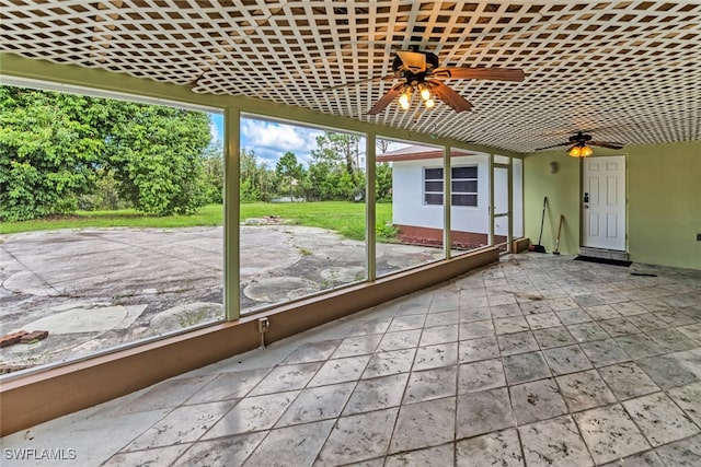 unfurnished sunroom featuring brick ceiling and ceiling fan