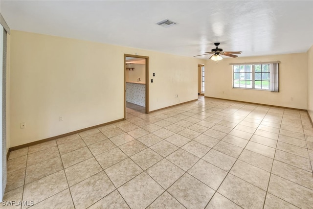 tiled spare room with ceiling fan