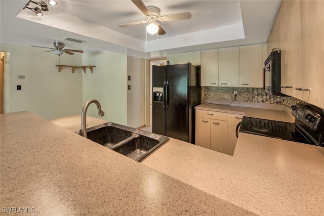 kitchen with tasteful backsplash, sink, ceiling fan, black appliances, and a raised ceiling