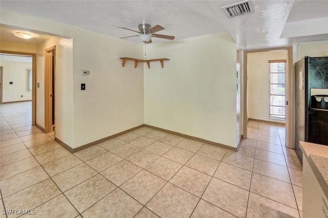 tiled empty room featuring ceiling fan