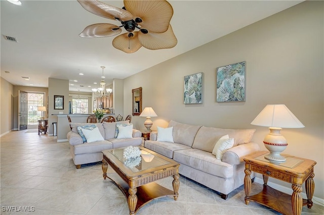 living room featuring ceiling fan with notable chandelier and light tile patterned floors