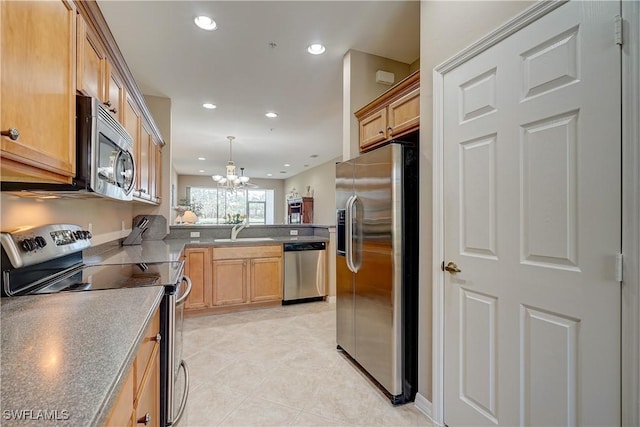 kitchen with kitchen peninsula, stainless steel appliances, sink, pendant lighting, and a chandelier