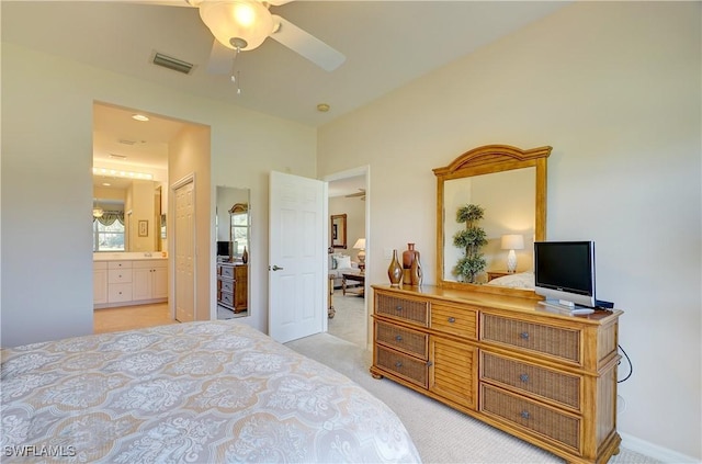 carpeted bedroom featuring ensuite bathroom, a closet, and ceiling fan