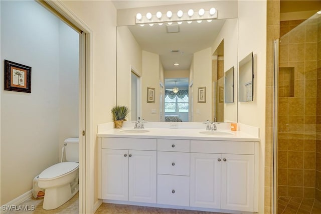 bathroom with vanity, toilet, and a shower with shower door