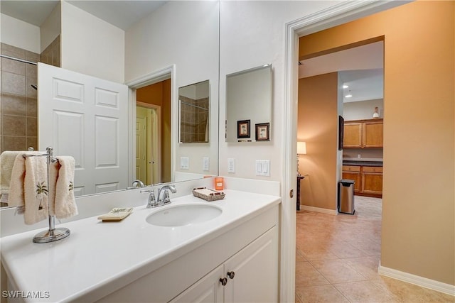 bathroom with tile patterned floors, vanity, and tiled shower