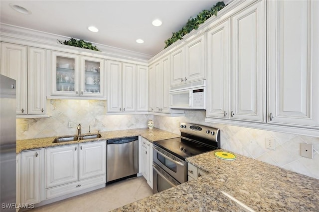 kitchen with white cabinets, sink, light stone countertops, light tile patterned floors, and stainless steel appliances