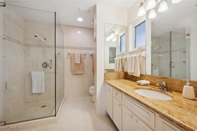 bathroom with vanity, tile patterned flooring, a shower with door, and toilet