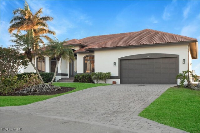 mediterranean / spanish-style house featuring a front lawn and a garage