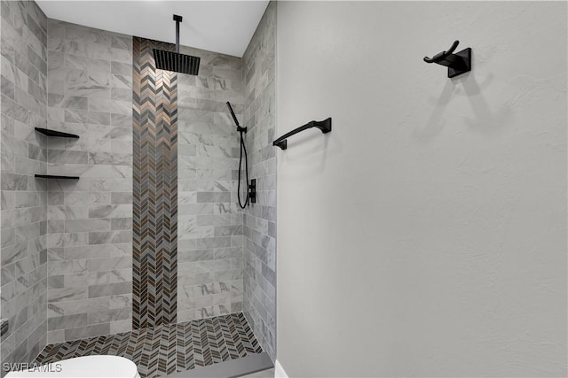 bathroom featuring toilet and tiled shower