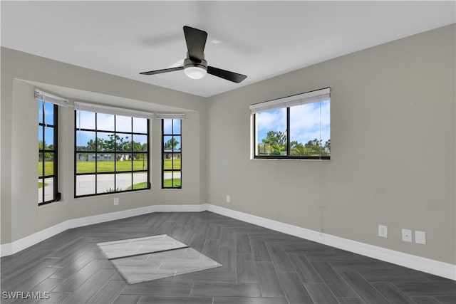 spare room with ceiling fan and dark parquet floors