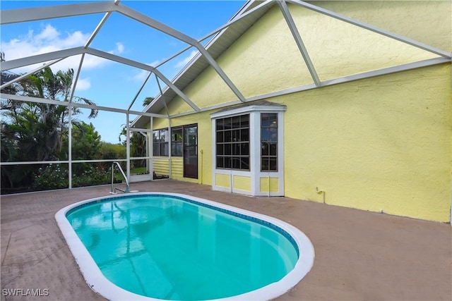 view of swimming pool featuring a patio area and glass enclosure