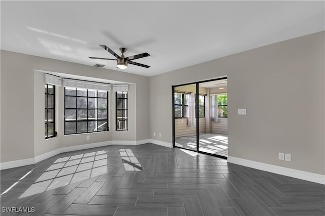 spare room featuring ceiling fan and dark parquet floors