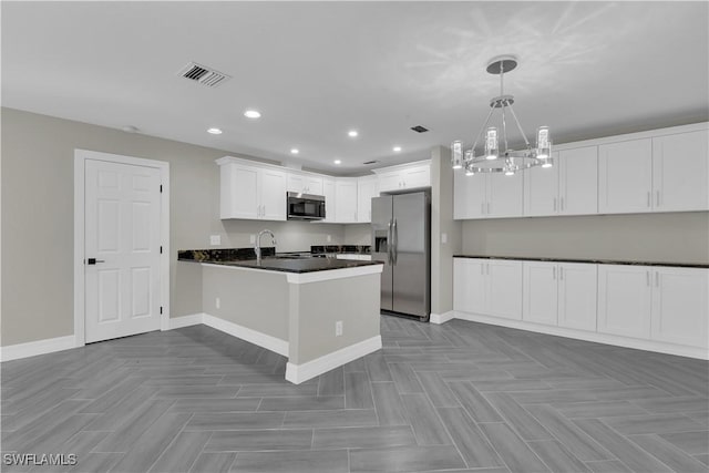 kitchen with kitchen peninsula, appliances with stainless steel finishes, sink, decorative light fixtures, and white cabinets