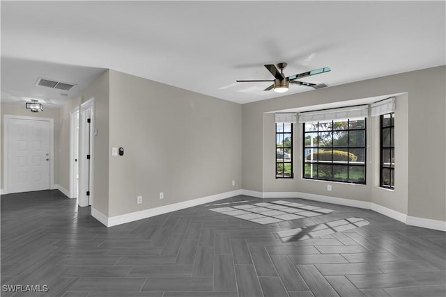 empty room with ceiling fan and dark parquet floors