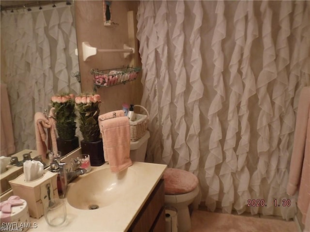 bathroom featuring vanity, curtained shower, and toilet