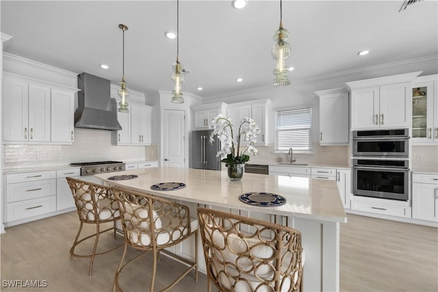 kitchen featuring sink, white cabinetry, wall chimney exhaust hood, and a center island