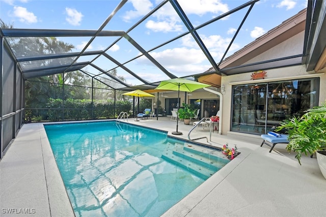 view of swimming pool with glass enclosure and a patio area