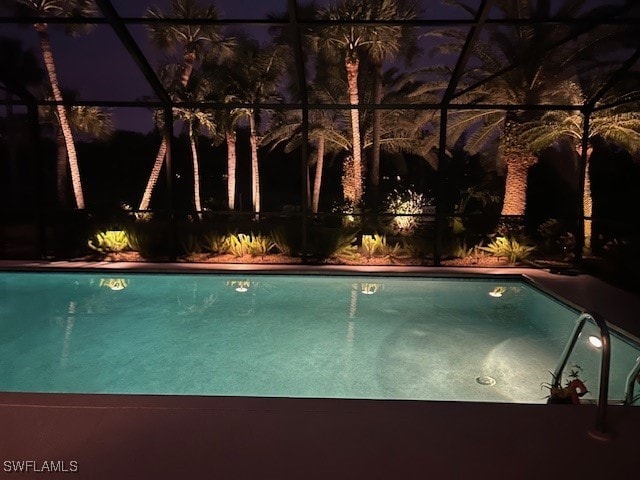 pool at twilight with a lanai