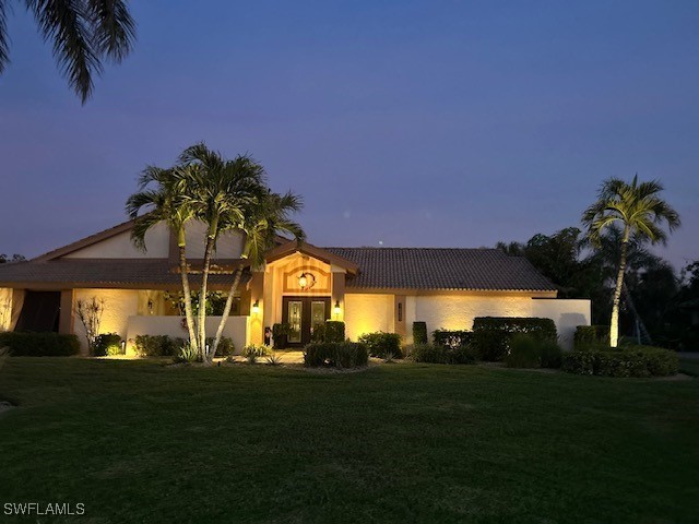 mediterranean / spanish home featuring a yard and french doors