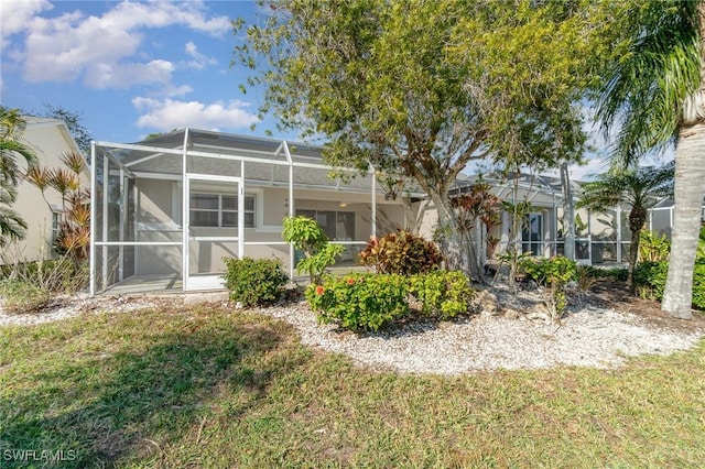 back of property featuring a lanai and a yard