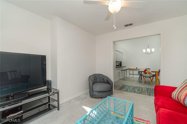 living room with concrete floors and ceiling fan with notable chandelier