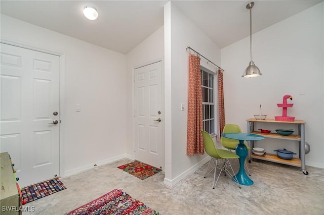 foyer entrance with concrete floors and vaulted ceiling