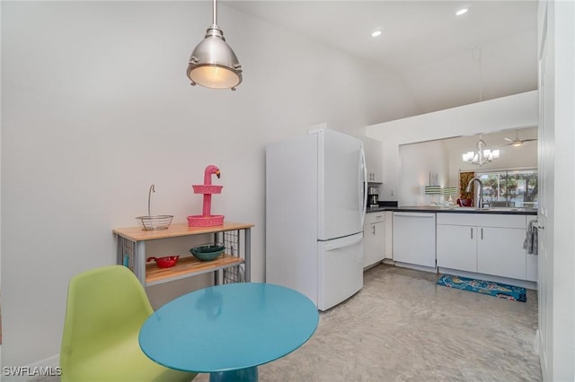 kitchen with white appliances, decorative light fixtures, white cabinetry, and sink