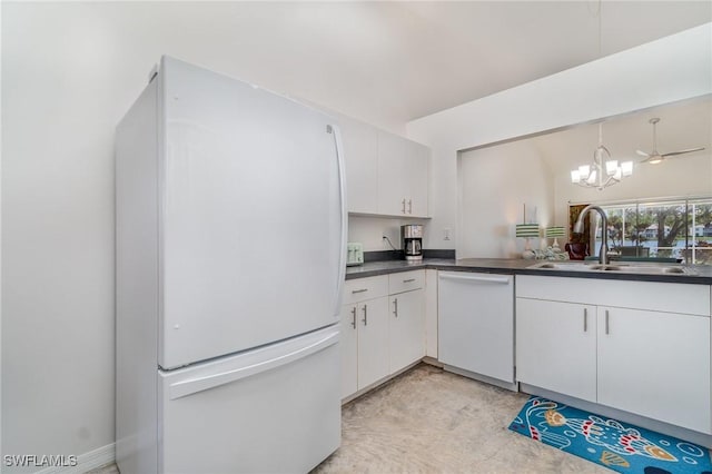 kitchen with pendant lighting, white appliances, sink, a notable chandelier, and white cabinetry