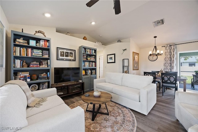 living room featuring dark wood-type flooring, lofted ceiling, and ceiling fan with notable chandelier