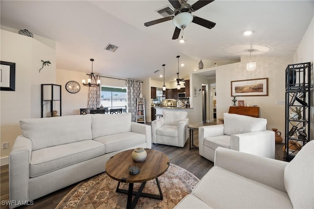 living room with vaulted ceiling, dark wood-type flooring, and ceiling fan with notable chandelier