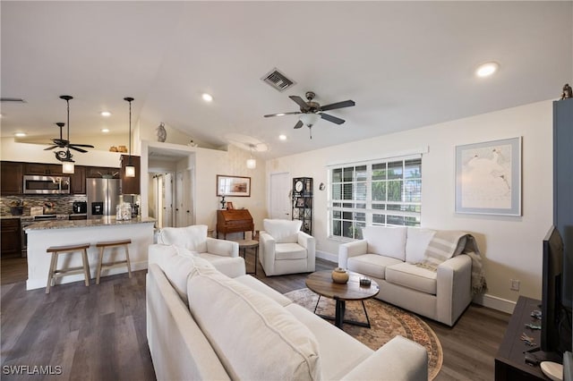 living room with ceiling fan, vaulted ceiling, and dark wood-type flooring