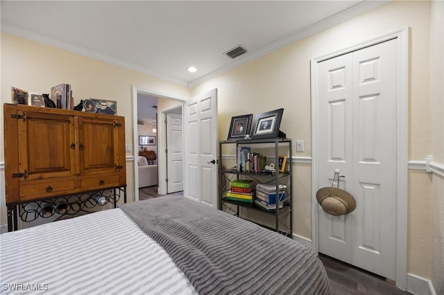 bedroom featuring dark hardwood / wood-style floors, a closet, and crown molding