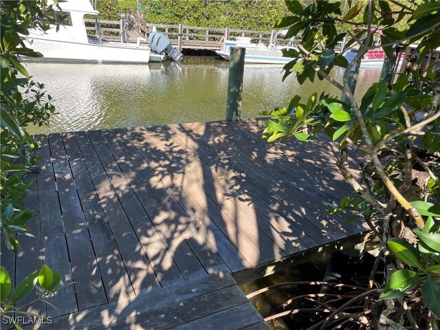 dock area with a water view and an outdoor pool