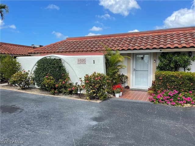 view of front of home with a tile roof and stucco siding