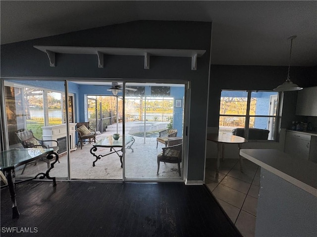 doorway with hardwood / wood-style flooring, lofted ceiling, plenty of natural light, and ceiling fan